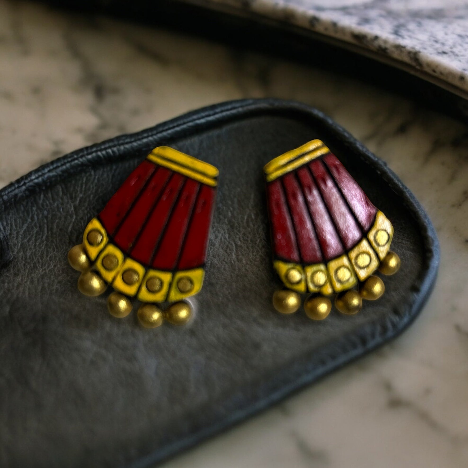 Red stud style earrings in terracotta
